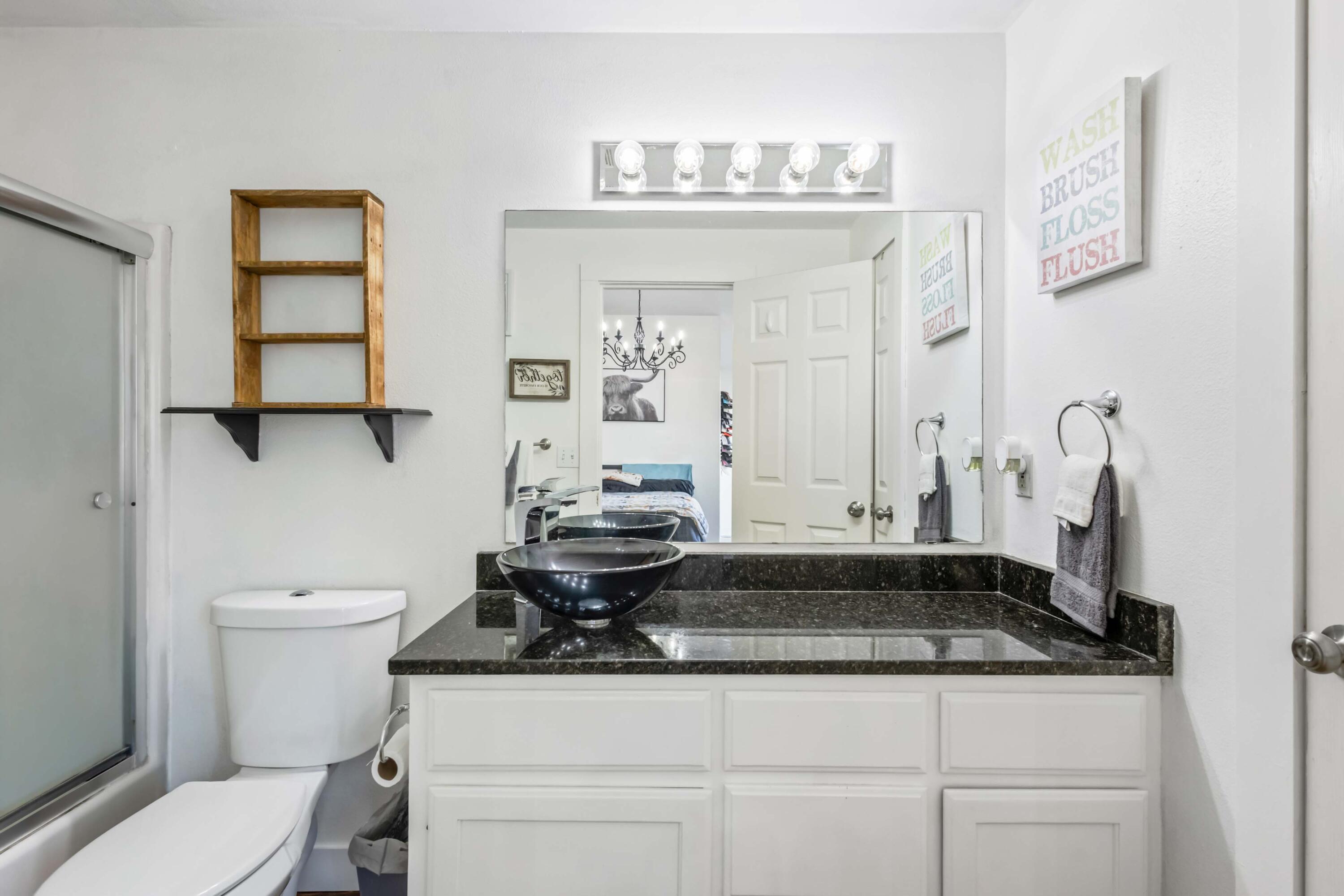 405 East D Street Culver, OR 97734 - Photo 16 of 49 a bathroom with a granite countertop sink a toilet and a mirror