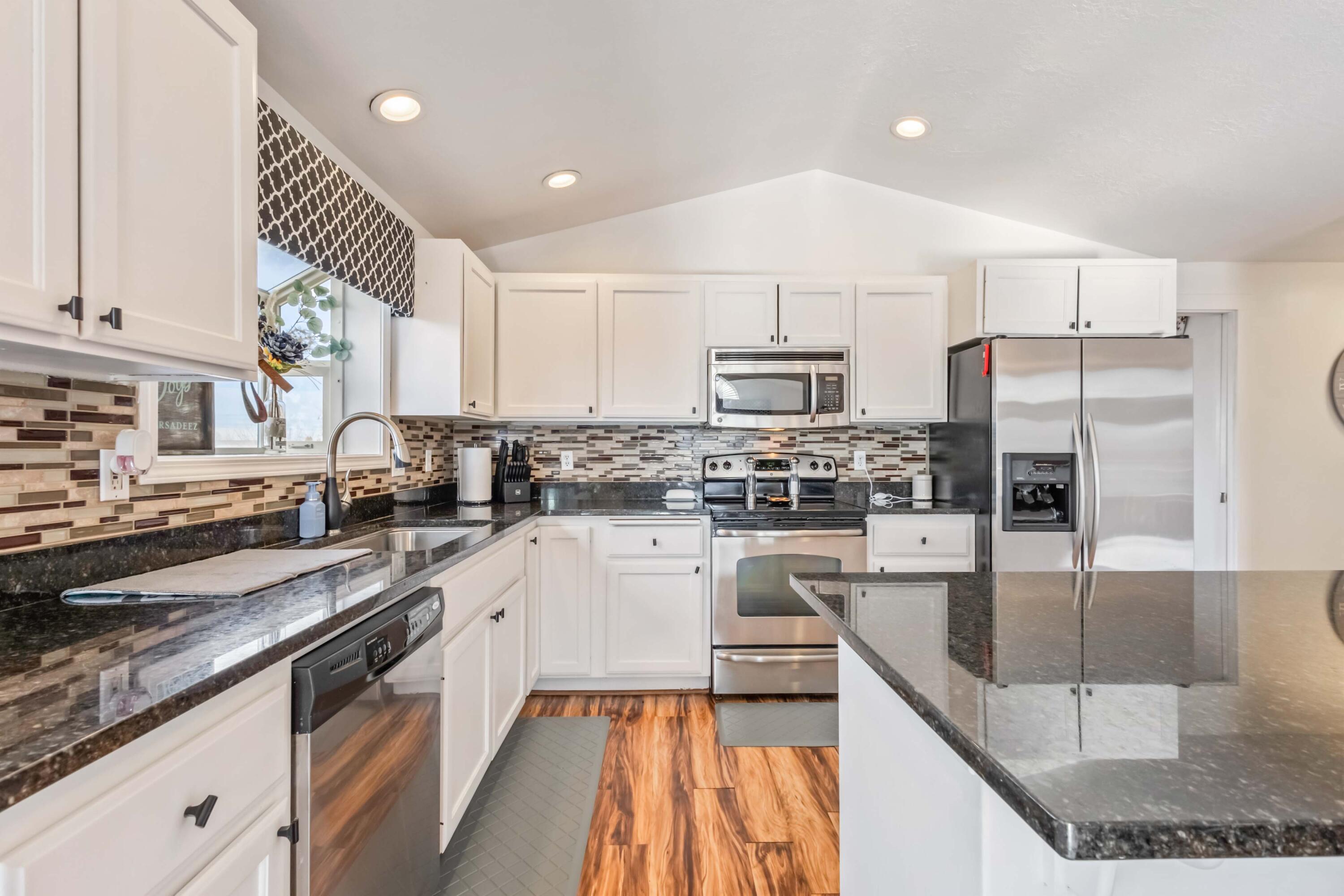405 East D Street Culver, OR 97734 - Photo 10 of 49 a kitchen with stainless steel appliances granite countertop a sink a stove and cabinets
