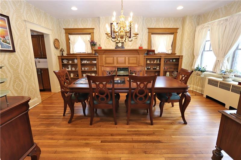 Dining Room with built-in shelving, gas fireplace & brass chandelier.