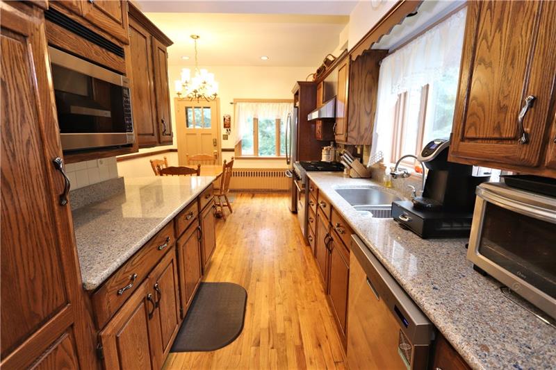 Kitchen has oak cabinets & quartz counters, built-in microwave & dishwasher.