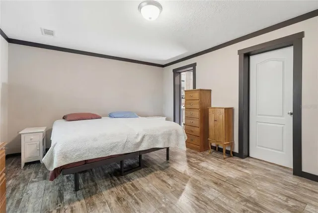 a bedroom with a bed and wooden floor