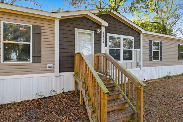 a view of a house with wooden stairs and a small yard