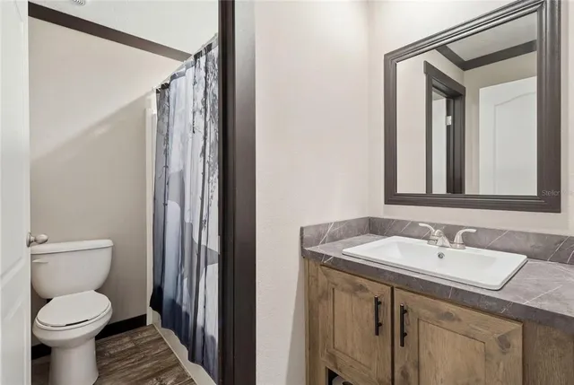 a bathroom with a granite countertop sink toilet and shower