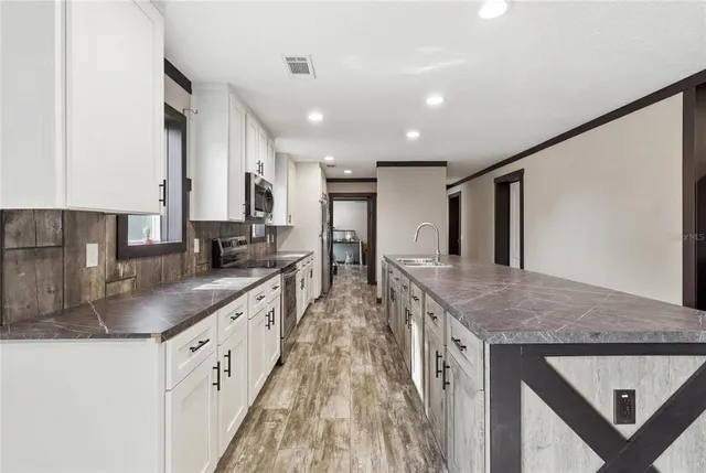 a kitchen with granite countertop a sink stove and refrigerator