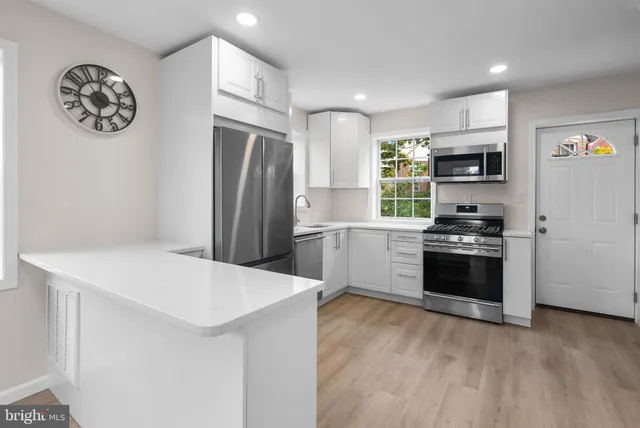 a kitchen with granite countertop a refrigerator and a stove top oven