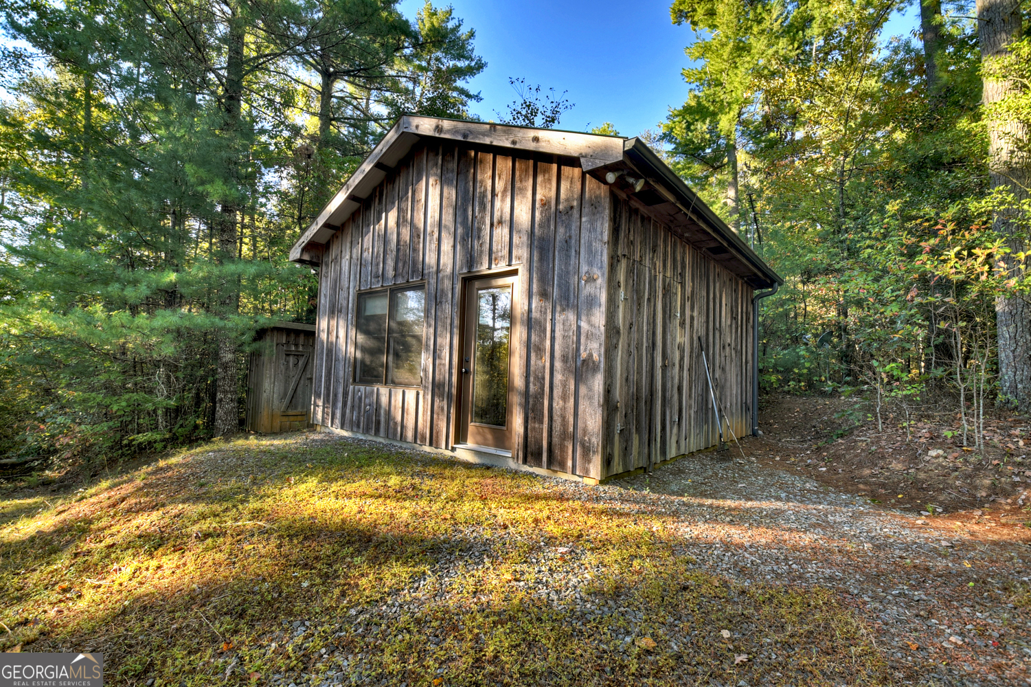 a view of a small house with backyard and trees