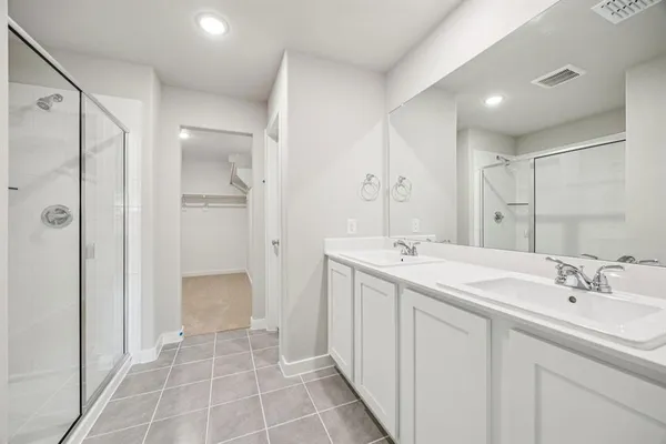 a spacious bathroom with a shower sink and mirror