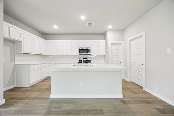 a view of kitchen with stainless steel appliances granite countertop a sink a stove and a refrigerator