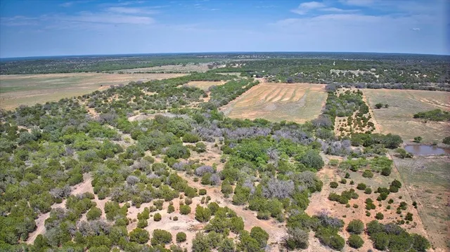 an aerial view of a house with a yard and trees