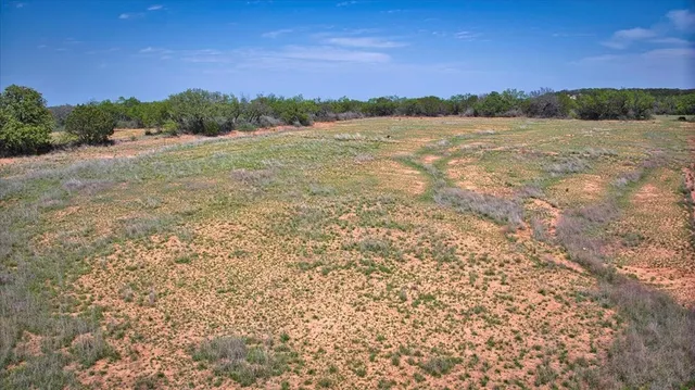a view of a swimming pool with a patio and a yard