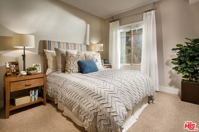 a bedroom with a bed and a potted plant