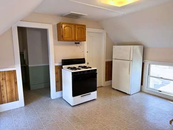 a kitchen with a refrigerator and a stove top oven
