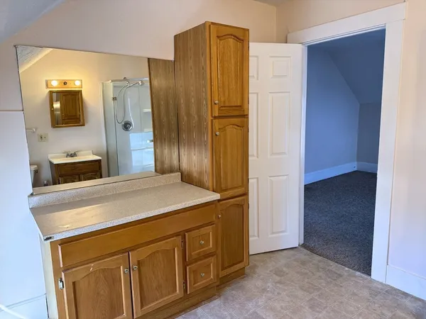 a bathroom with a granite countertop sink and a mirror