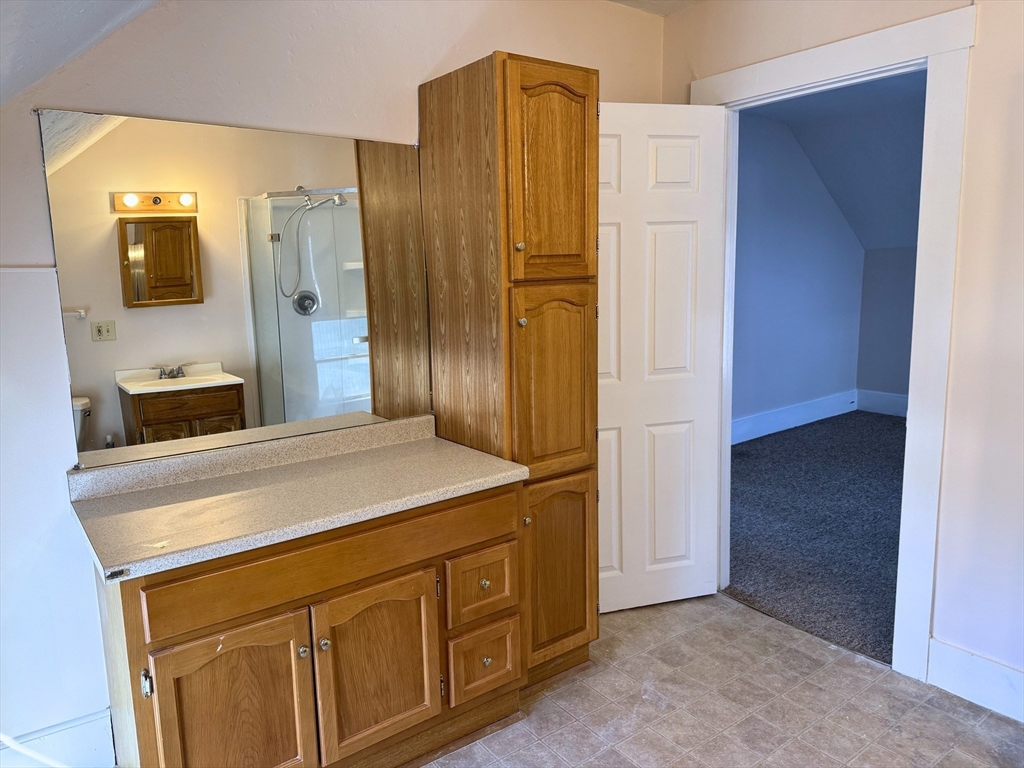 29 Fletcher Street, Unit 2 Ayer, MA 01432 - Photo 9 of 15 a bathroom with a granite countertop sink and a mirror