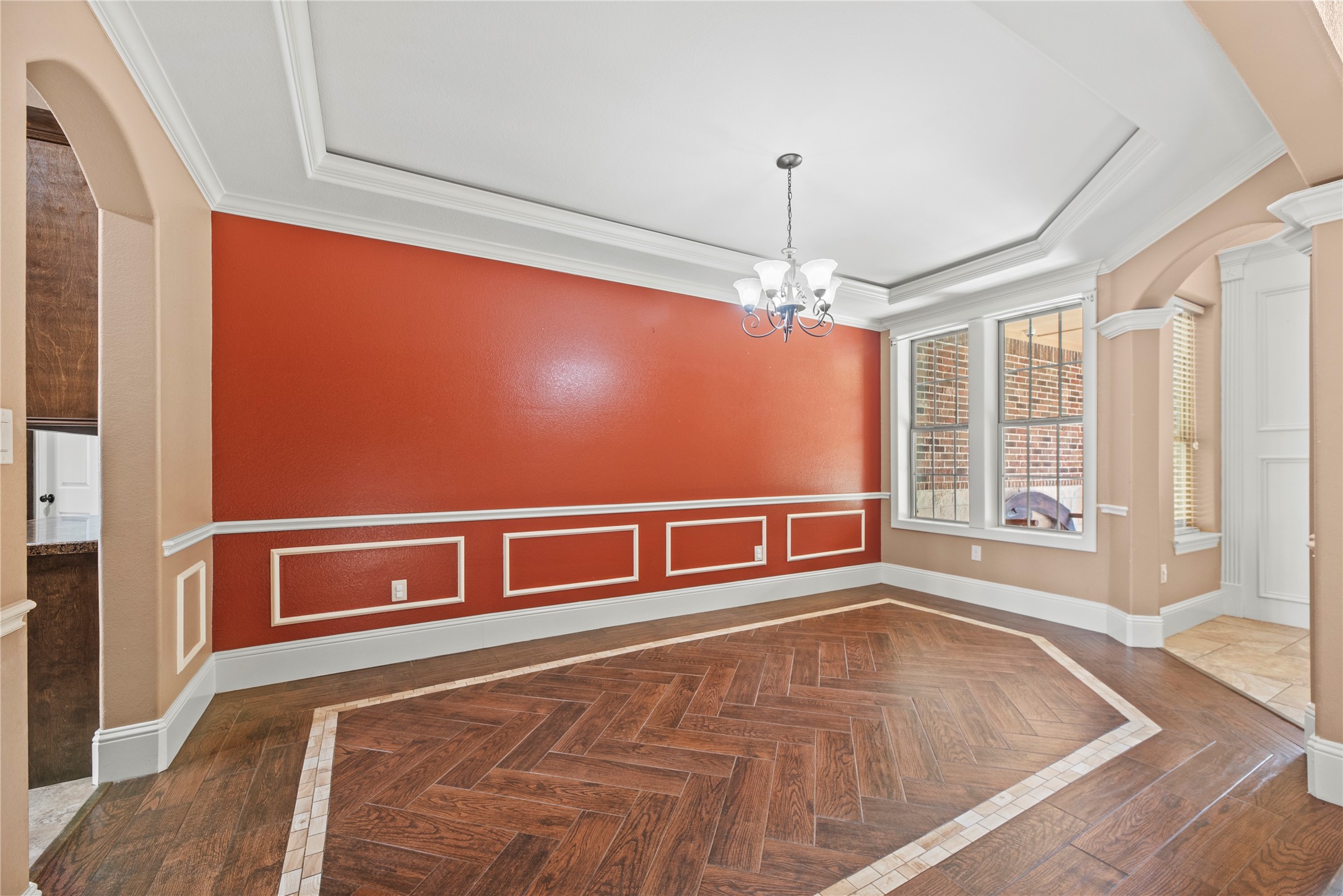 30914 Coco Street Cypress, TX 77433 - Photo 11 of 47 Formal dining just off the foyer with a tray ceiling, crown molding, decorative wood-look tile flooring and an elegant chandelier.
