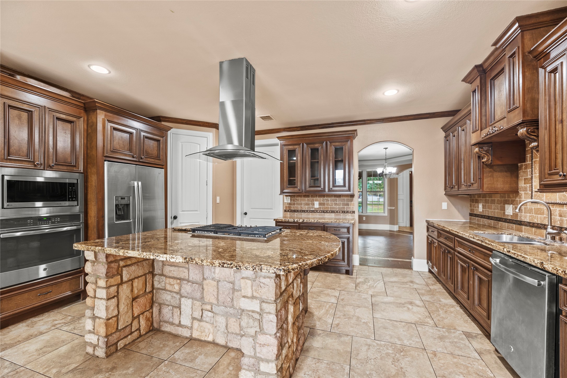 30914 Coco Street Cypress, TX 77433 - Photo 16 of 47 Gourmet kitchen features granite countertops, tile backsplash, stainless steel appliances, glass front cabinets and a large island with a gas cooktop.