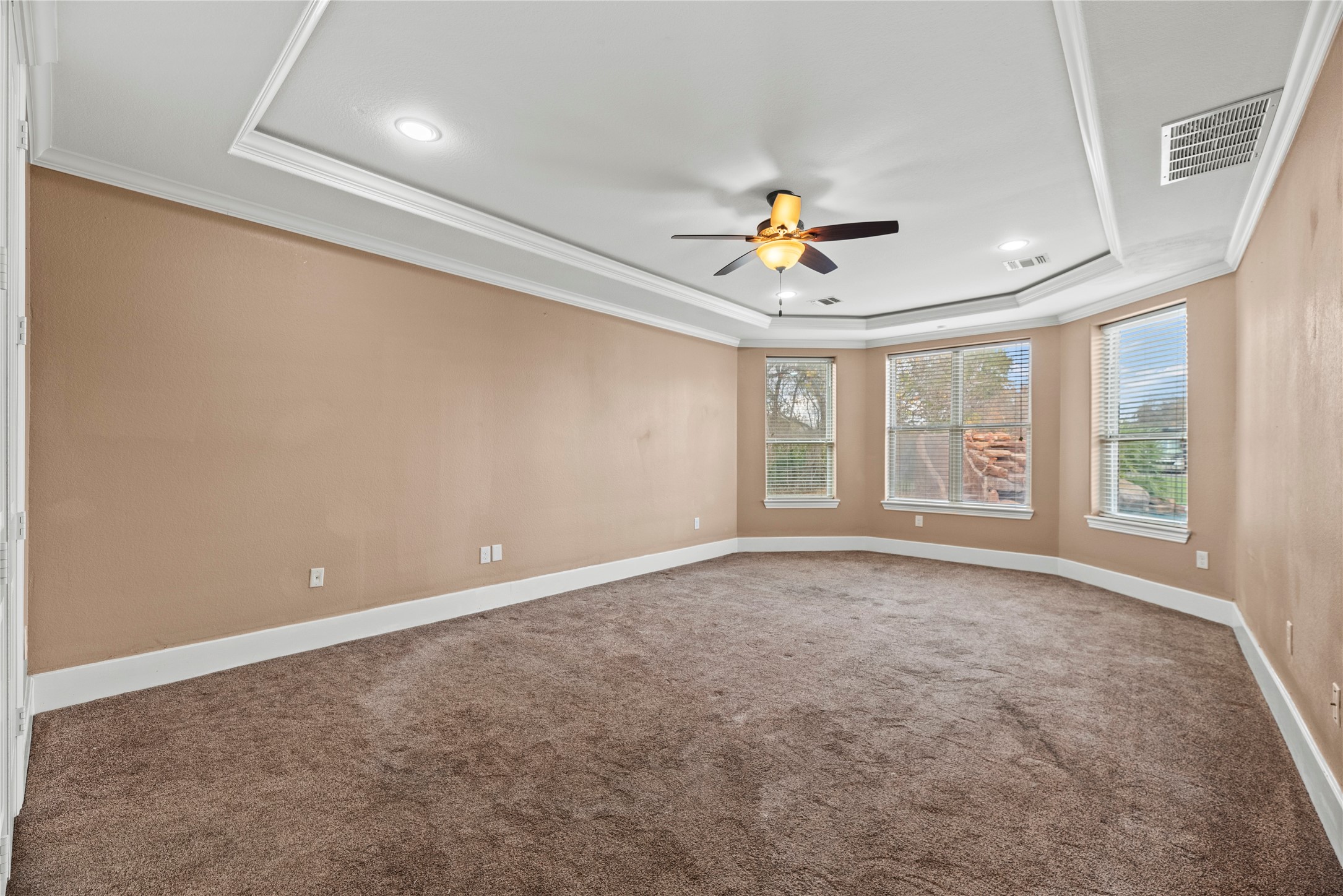 30914 Coco Street Cypress, TX 77433 - Photo 21 of 47 Huge primary retreat with a tray ceiling, crown molding, ceiling fan, sitting area, en-suite bathroom and great backyard views.