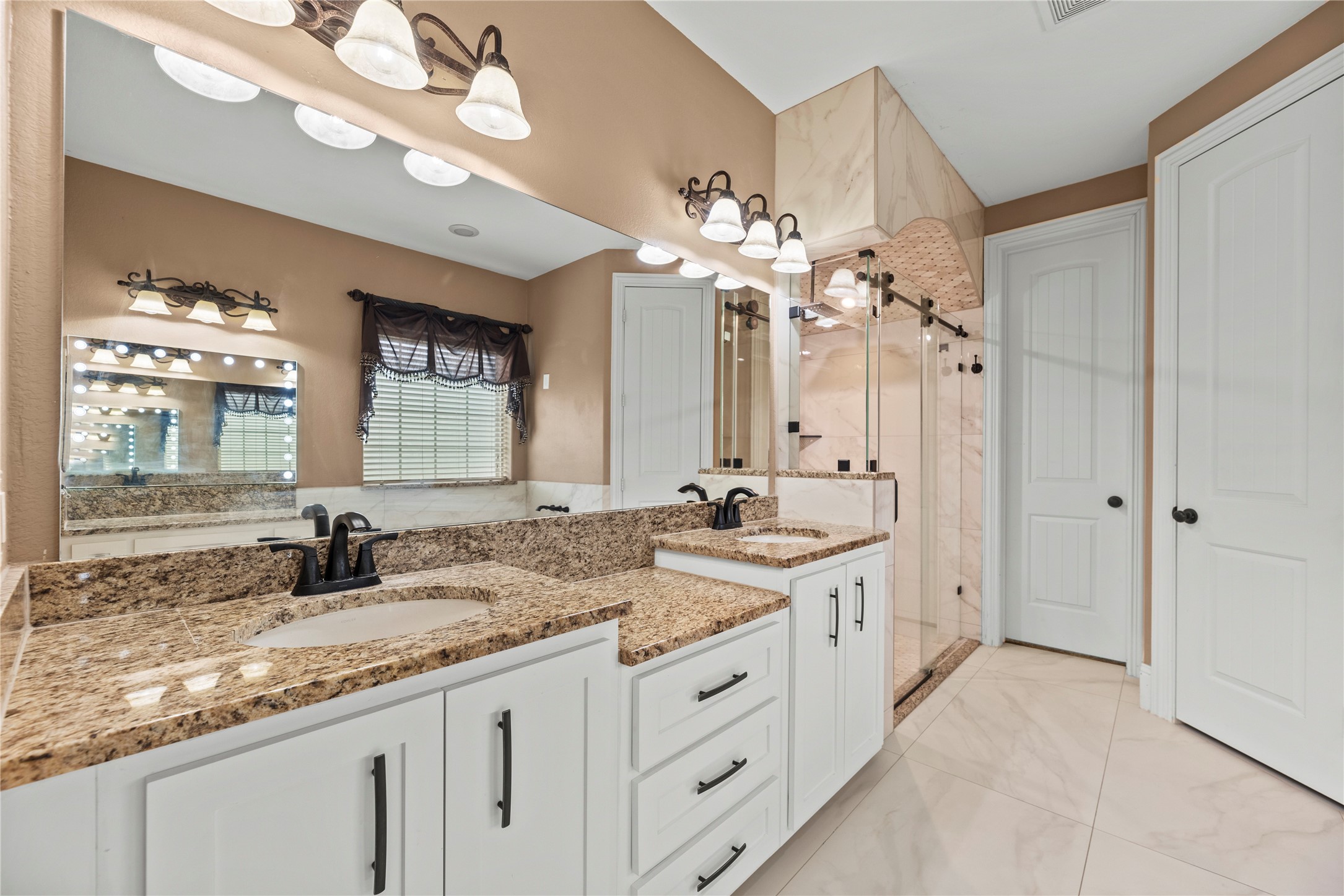 30914 Coco Street Cypress, TX 77433 - Photo 23 of 47 Spa-like primary bathroom is complete with a dual sink vanity, separate makeup vanity, soaking tub, oversized shower and a large walk-in closet with built-ins.