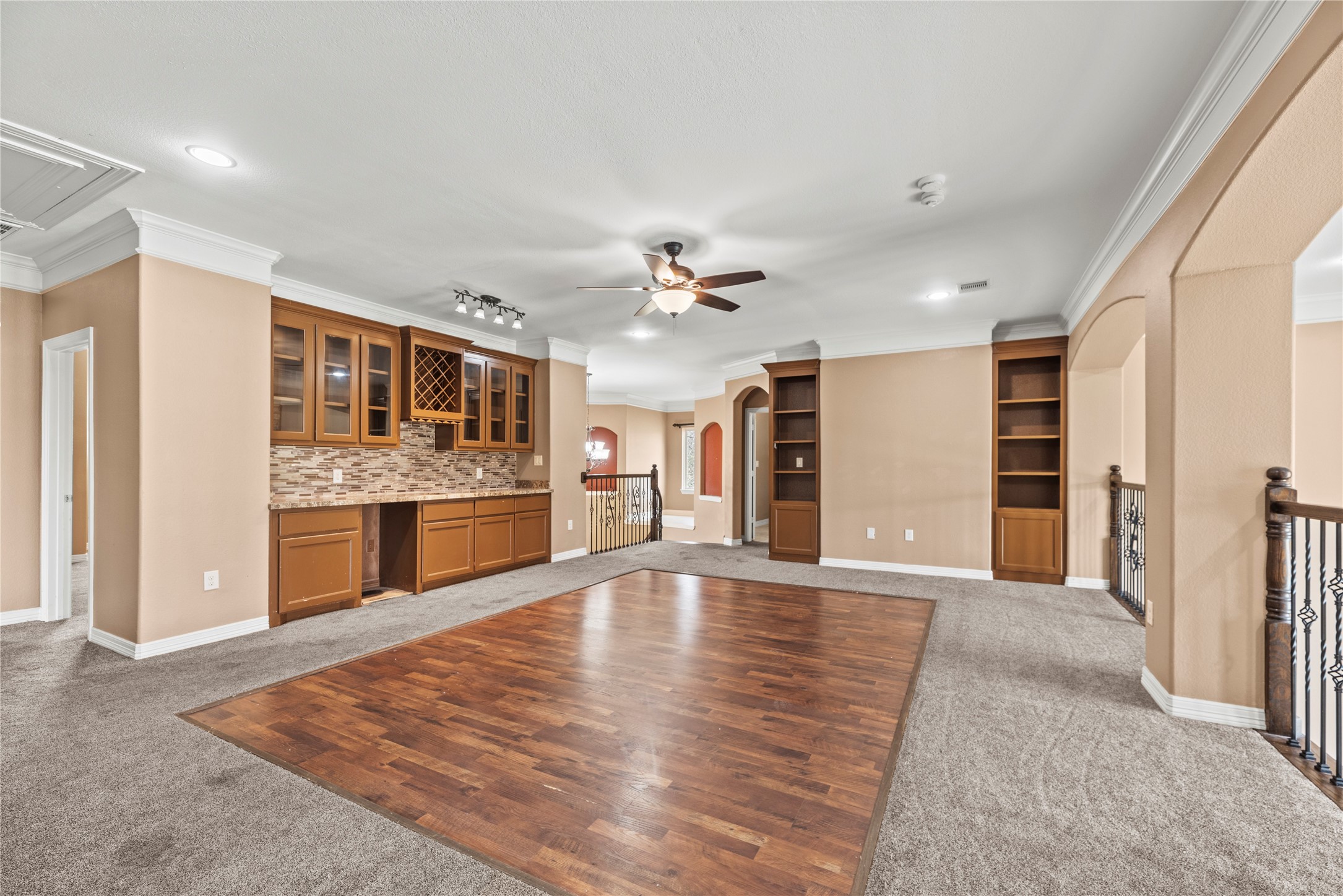 30914 Coco Street Cypress, TX 77433 - Photo 26 of 47 Upstairs game room with a large dry bar, glass tile backsplash, glass front cabinets, wine rack, built-ins and access to the outdoor balcony.