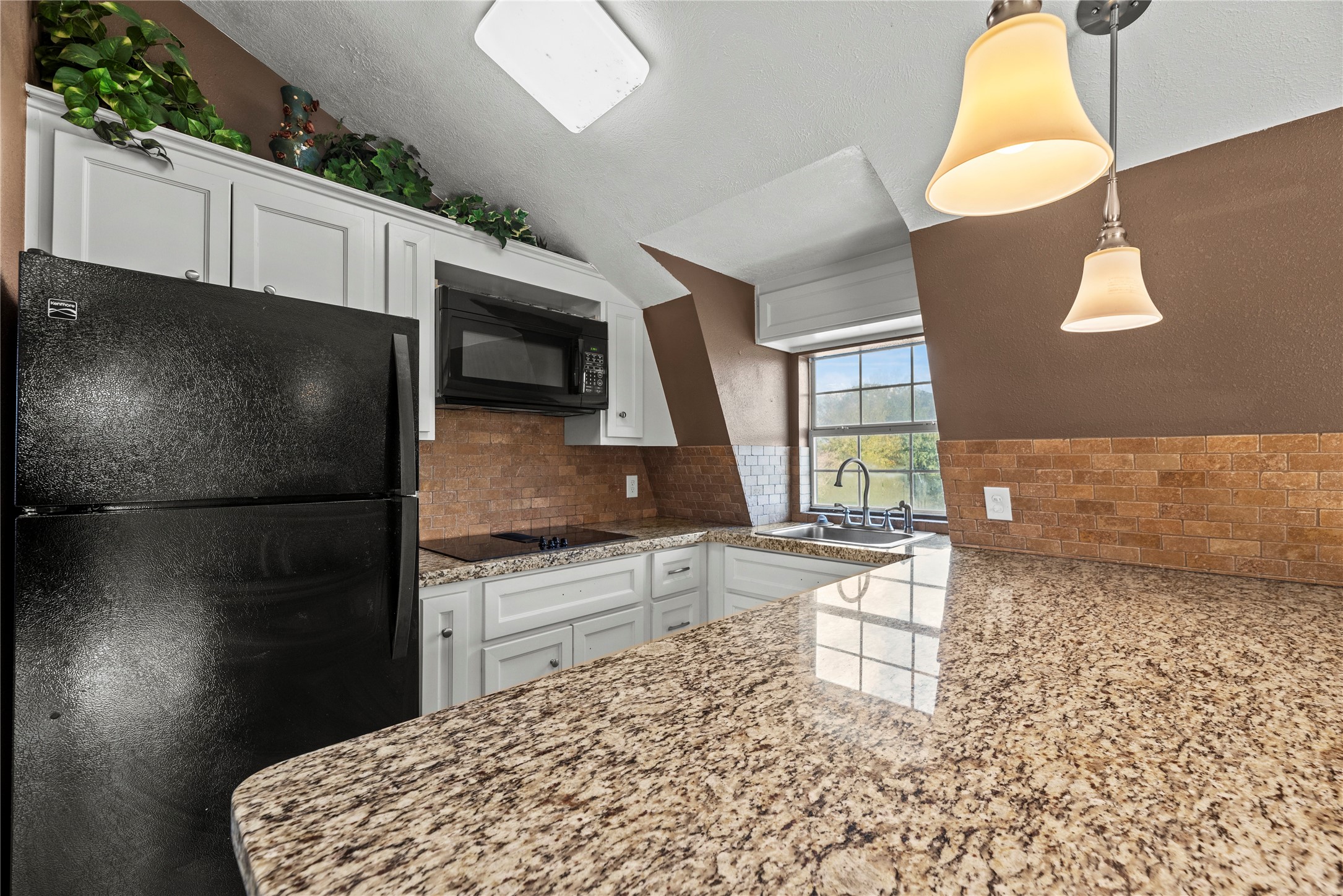 30914 Coco Street Cypress, TX 77433 - Photo 45 of 47 Kitchen in the apartment includes beautiful granite countertops and black appliances.