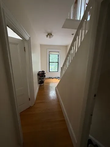 a view of entryway and hall with wooden floor