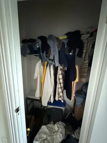 a view of walk in closet with clothes and shoes