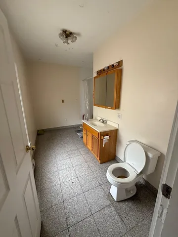 a bathroom with a toilet and a mirror