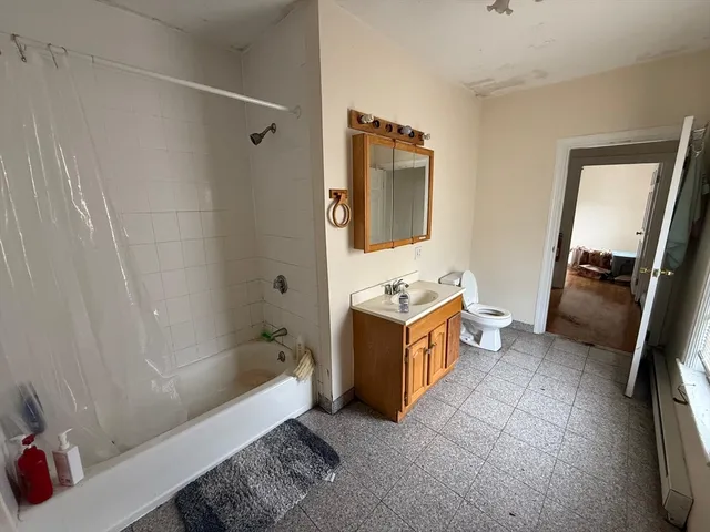 a bathroom with a tub sink and mirror