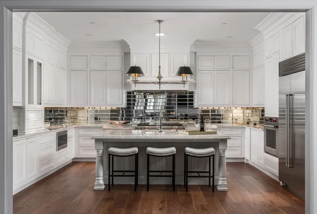 a kitchen with stainless steel appliances a dining table chairs sink and stove top oven