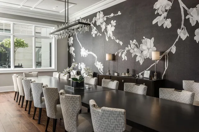 a view of a dining room with furniture a chandelier and large windows