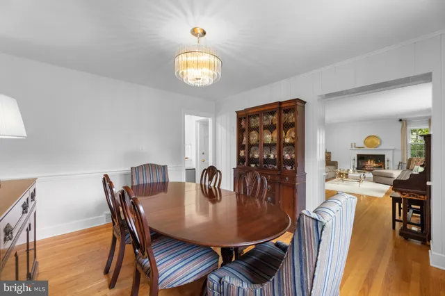 a large kitchen with stainless steel appliances kitchen island a stove a refrigerator a oven and a sink with wooden floor