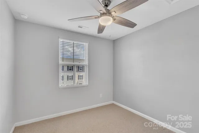 an empty room with a window and a fan