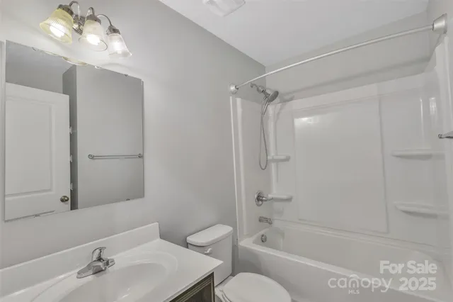a bathroom with a bathtub shower sink vanity and toilet