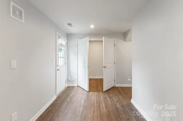 a view of empty room with wooden floor