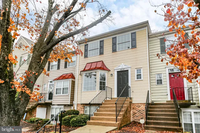 a view of a white house with a large tree