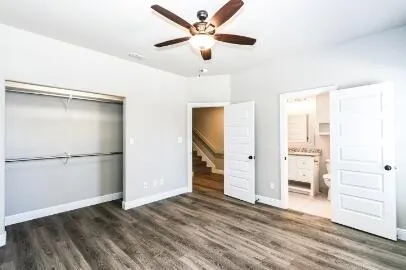 a view of empty room with wooden floor and ceiling fan