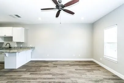 a view of a kitchen with a sink hardwood floor and a window