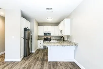 a kitchen with a sink a refrigerator and cabinets