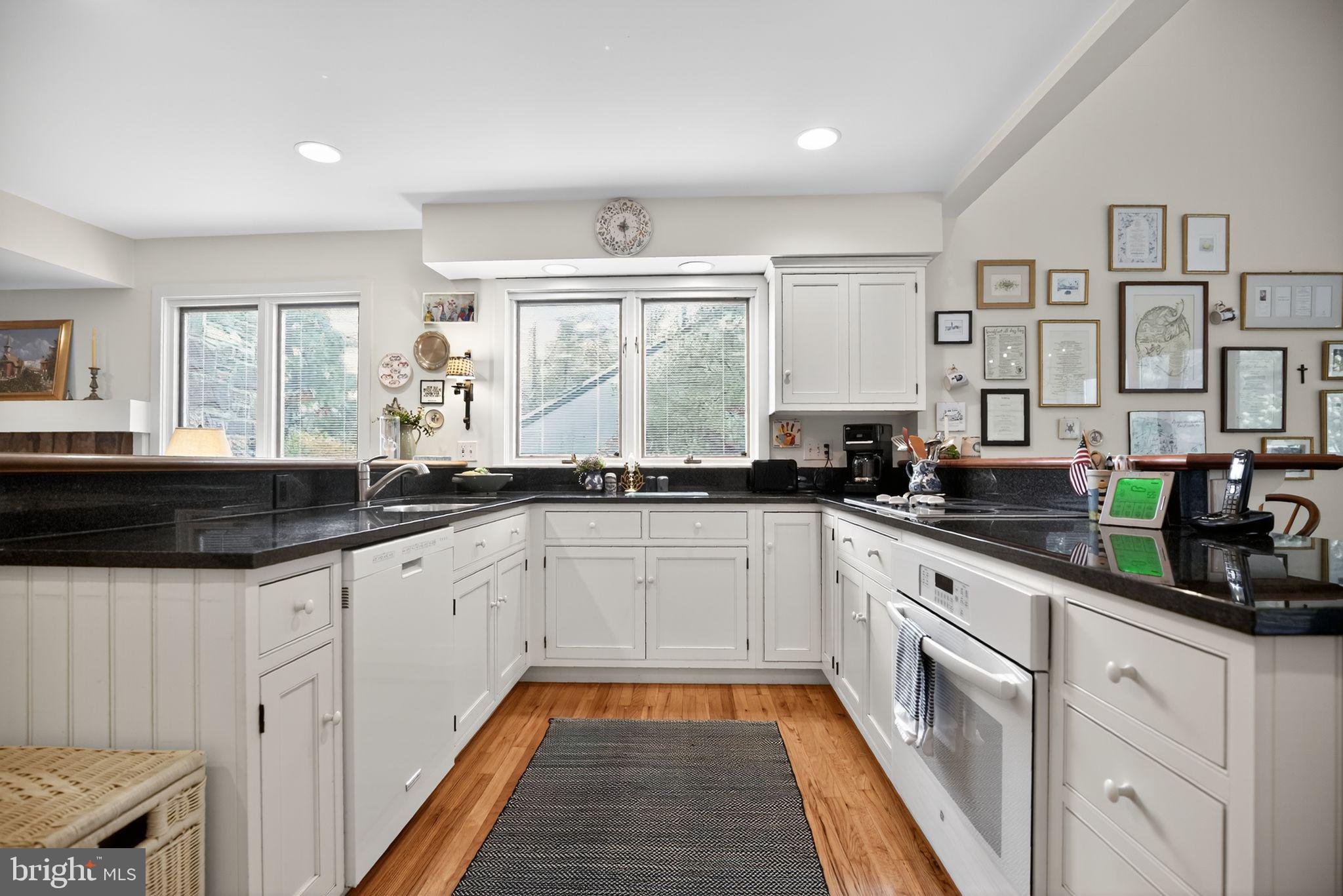 1 Fox Pond Place Spring House, PA 19477 - Photo 17 of 56 a large white kitchen with granite countertop a sink and dishwasher a stove with wooden floor