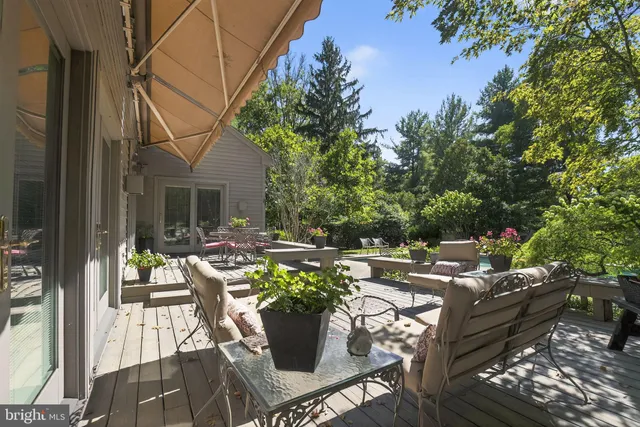 a view of a house with pool table and chairs under an umbrella
