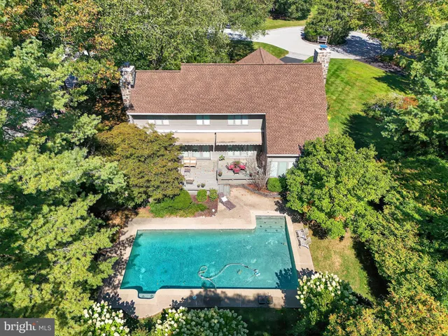 an aerial view of residential houses with outdoor space and trees