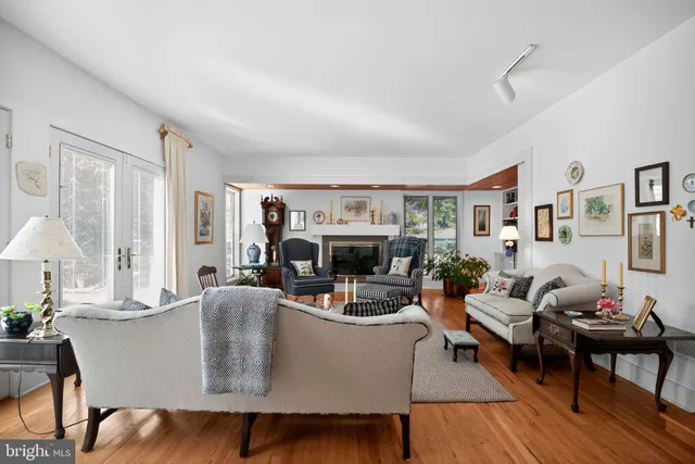 a living room with fireplace furniture and a large window