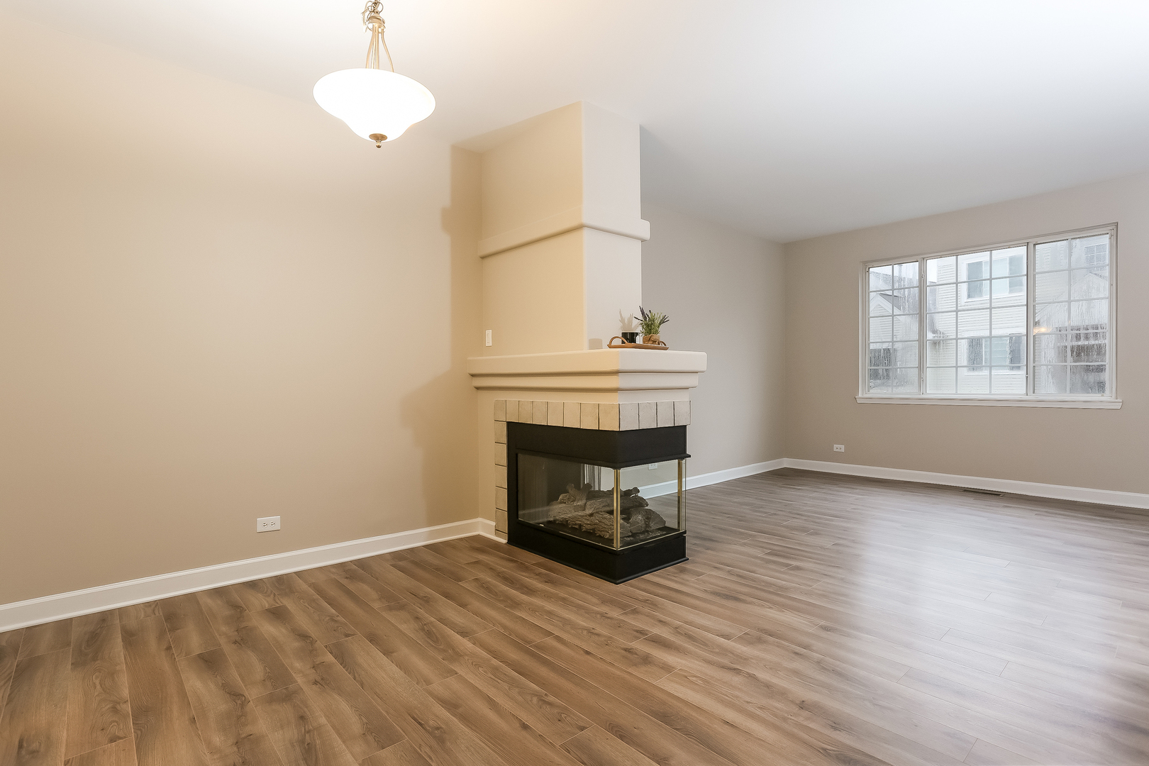 3462 Ravinia Circle Aurora, IL 60504 - Photo 3 of 17 an empty room with wooden floor fireplace and windows