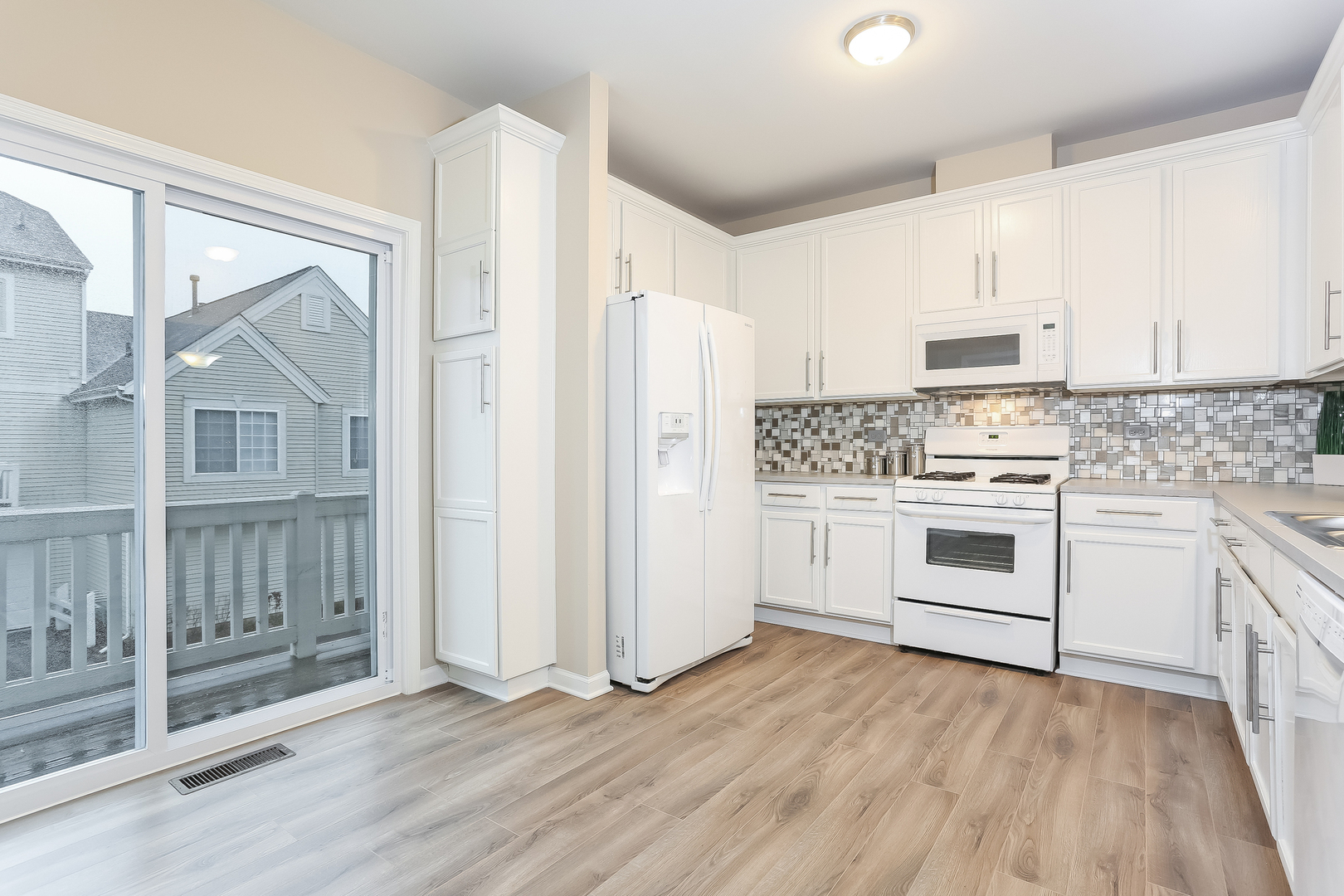 3462 Ravinia Circle Aurora, IL 60504 - Photo 5 of 17 a kitchen with white cabinets and white appliances