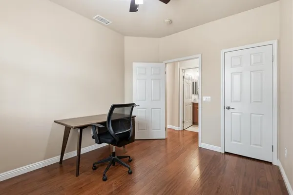 a view of a workspace with furniture and a window
