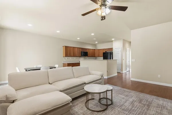 a living room with furniture and a wooden floor