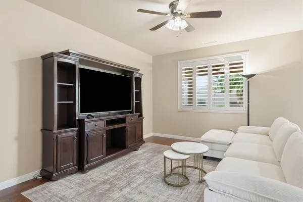 a living room with furniture a flat screen tv and a window