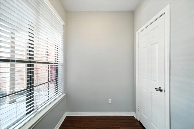 a view of a small space with wooden floor and a window