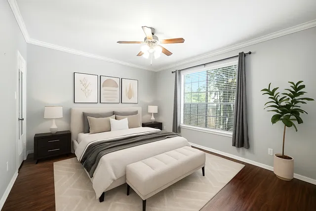 a bedroom with a large bed and a potted plant