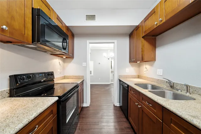 a kitchen with stainless steel appliances granite countertop a sink stove and microwave